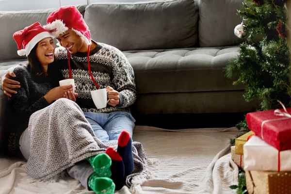 La Navidad es un tónico para nuestras almas. Fotografía de una joven pareja sentada en el suelo en casa. —  Fotos de Stock