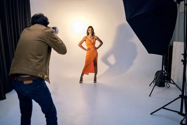 Now strike a pose. Shot of a photographer taking photos of a model in a studio. — Stock Photo, Image
