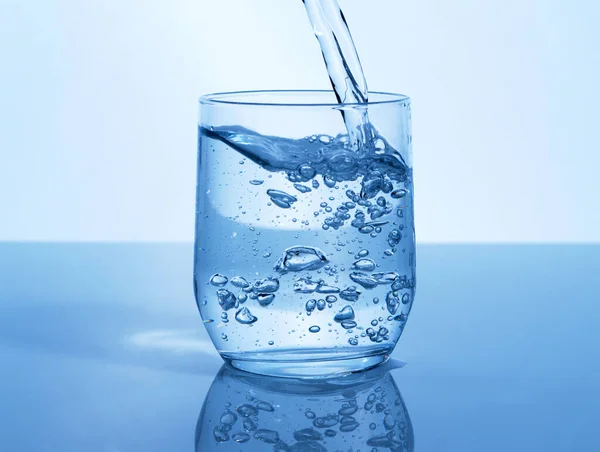 A glass of water can do the world of good. Studio shot of a glass of water being poured in studio. — Stock Photo, Image