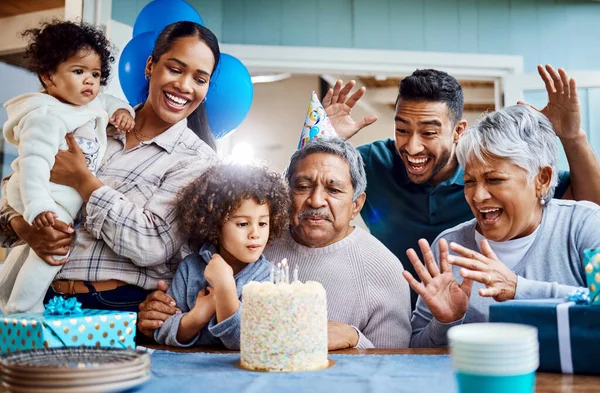 Make a wish. Shot of a little boy celebrating his birthday with his family at home. — Stock Photo, Image