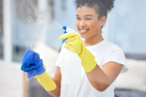 Limpiando esas ventanas chirriando. Un disparo de una mujer joven limpiando las ventanas en casa. —  Fotos de Stock
