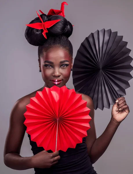 Inspirado por el este. Retrato de estudio de una hermosa joven vestida con maquillaje inspirado en Asia y posando con origami sobre un fondo gris. —  Fotos de Stock