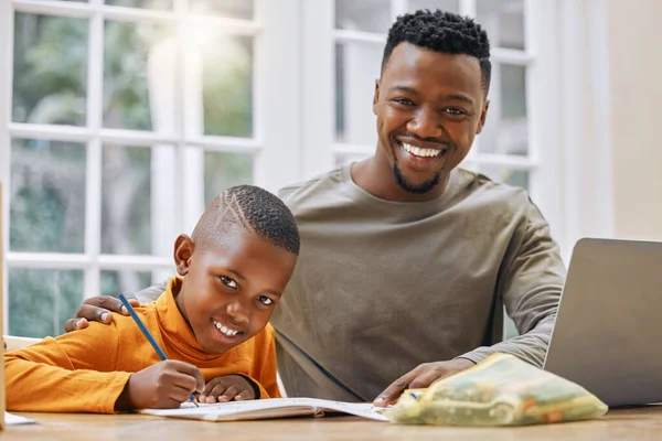 Een vaderbegeleiding zal je ver brengen. Schot van een jonge vader helpen zijn zoon met huiswerk thuis. — Stockfoto