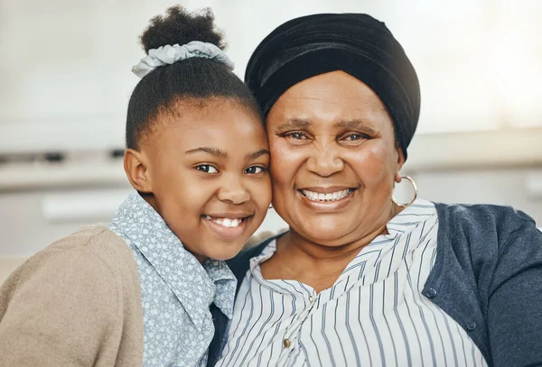 Gezond houdt van rassen gelukkige kinderen. Shot van een oma bonding met haar kleindochter op een bank thuis. — Stockfoto