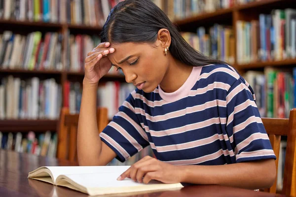 Receta para el éxito. Fotografía de una joven estudiante leyendo un libro en una biblioteca. — Foto de Stock
