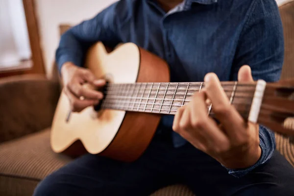 Está na hora de afinar estas habilidades. Tiro de um homem praticando suas habilidades de guitarra em casa. — Fotografia de Stock