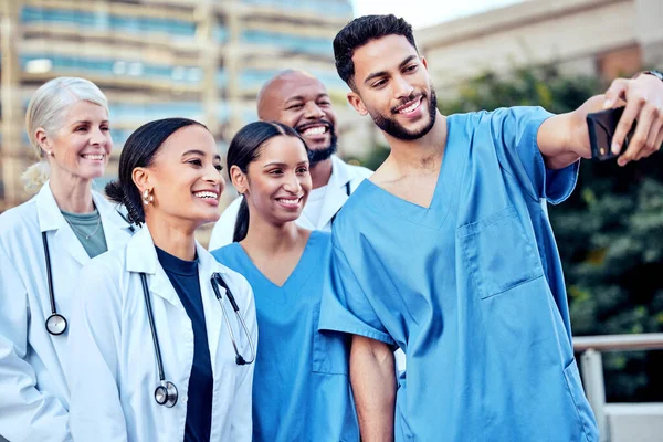 Uma selfie de trabalho não vai doer. Tiro de um grupo de médicos que tomam uma selfie na cidade. — Fotografia de Stock