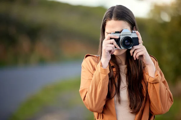 Ich werde viele Kilometer reisen und viele Fotos machen. Aufnahme einer jungen Frau, die ihre Kamera benutzt, während sie Zeit im Freien verbringt. — Stockfoto