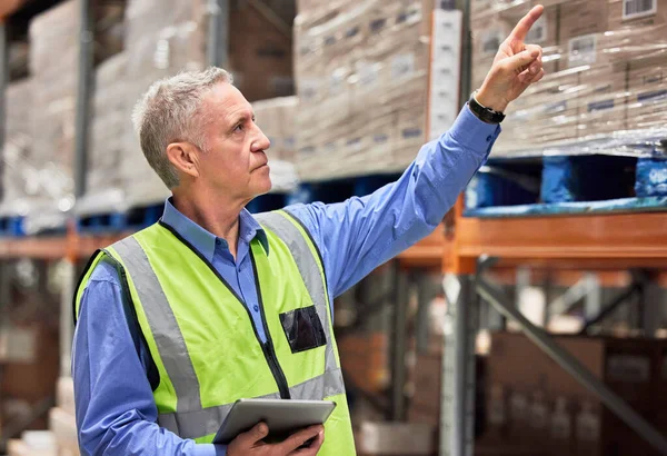 Een goede manager kan overal een goede manager zijn. Shot van een volwassen man met behulp van een digitale tablet tijdens het werken in een magazijn. — Stockfoto