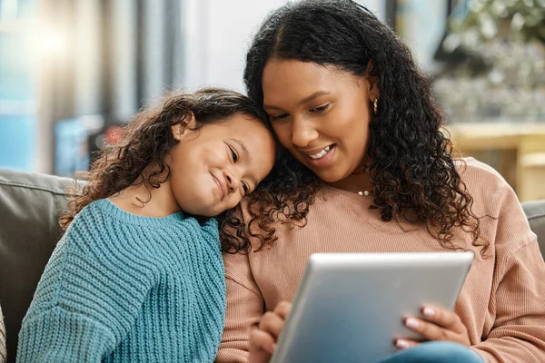 Das sieht doch gut aus, oder? Aufnahme einer attraktiven jungen Frau, die mit ihrer Tochter sitzt und während sie ein digitales Tablet benutzt. — Stockfoto