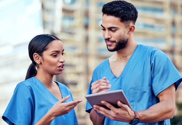 Att lära av varandra. Skjuten av två unga läkare med hjälp av en digital tablett i staden. — Stockfoto