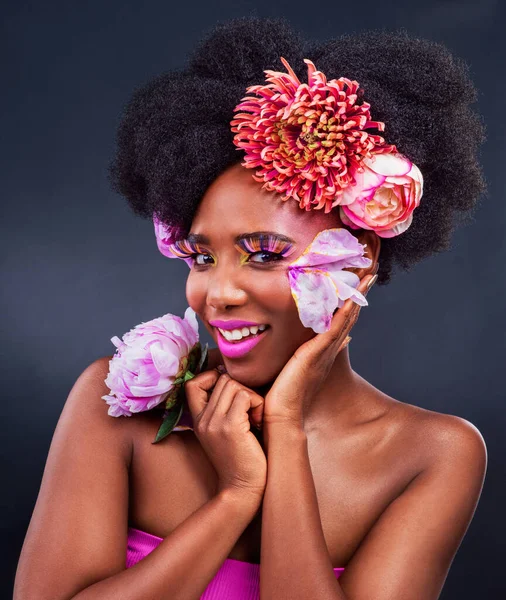 Τα λουλούδια προσθέτουν ομορφιά σε όλα. Στούντιο πλάνο μιας όμορφης νεαρής γυναίκας που ποζάρει με λουλούδια στα μαλλιά της. — Φωτογραφία Αρχείου