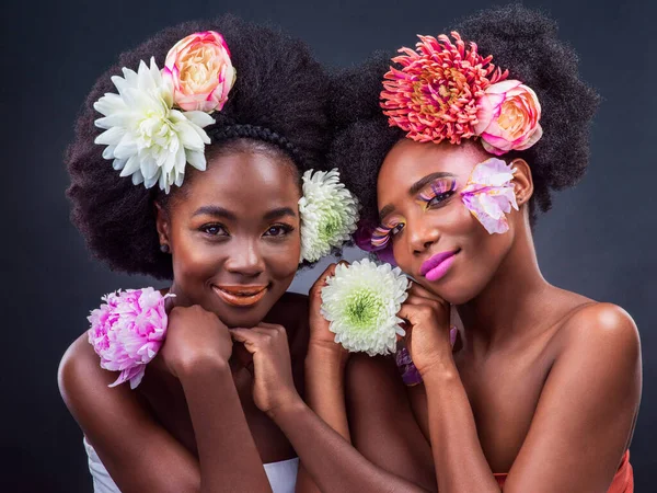 Were blossoming into the women weve always wanted to be. Cropped shot of two beautiful women posing together with flowers in their hair. — Stockfoto