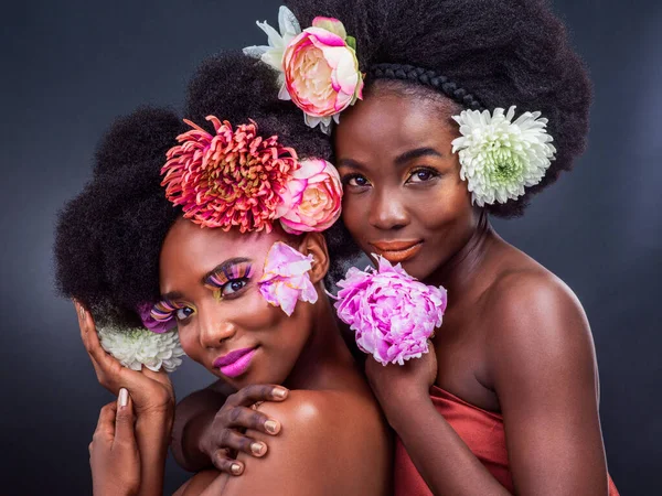 Όποια κι αν είναι η ερώτηση, η φύση είναι η απάντηση. Δύο όμορφες γυναίκες ποζάρουν μαζί με λουλούδια στα μαλλιά τους.. — Φωτογραφία Αρχείου