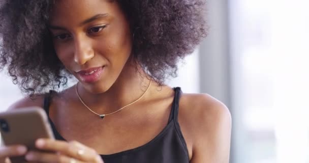 Να ενωθείς με έναν συνδεδεμένο κόσμο. Βίντεο 4k με μια ελκυστική νεαρή γυναίκα να στέλνει μηνύματα στο κινητό της στο σπίτι. — Αρχείο Βίντεο