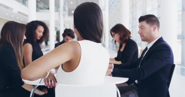 Youll go far when you show passion and dedication. 4k video footage of a young businesswoman smiling in an office during a meeting with her colleagues in the background. — Stok video