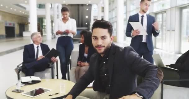Είμαι πάντα έτοιμος για δουλειά. Βίντεο 4k ενός επιχειρηματία που κοιτάζει την κάμερα ενώ κάθεται με μια ομάδα επιχειρηματιών. — Αρχείο Βίντεο