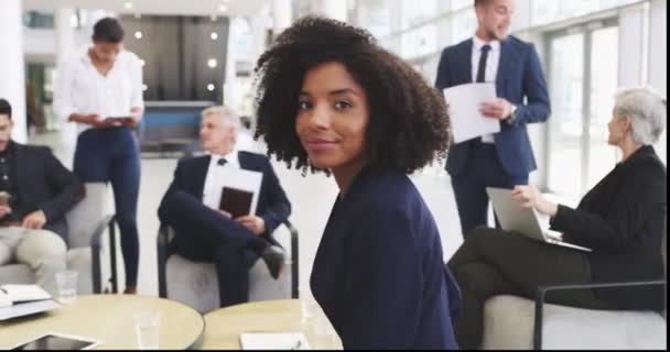 Wszędzie tam, gdzie jest sukces. Nagranie wideo 4k młodej bizneswoman uśmiechniętej w biurze z kolegami w tle. — Wideo stockowe