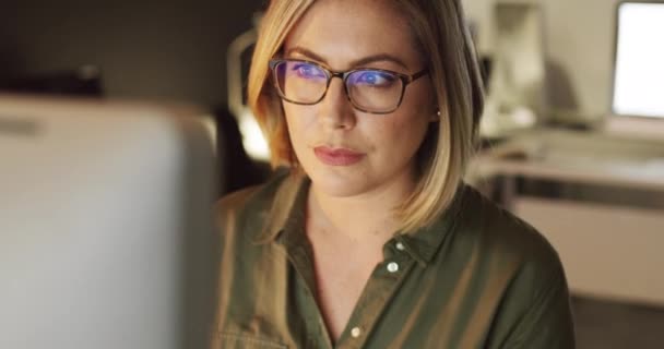 Centrado en hacer que el éxito suceda. 4k video de una joven empresaria trabajando hasta tarde en una computadora en una oficina. — Vídeo de stock