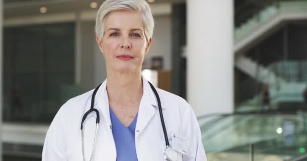 Jeg mener alvor med helsevesenet. 4k video av en attraktiv, moden kvinnelig lege som står med armene i kors på sykehuset. – stockvideo