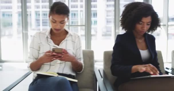 Your source of information matters a lot. 4k video footage of a group of businesspeople using digital devices while sitting in a line. — Vídeos de Stock