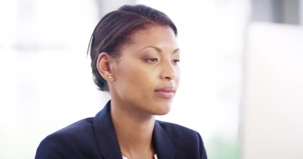 Shes completed all of her tasks for the day. 4k video footage of an attractive young businesswoman looking relaxed while working on a desktop in her office. — Vídeos de Stock