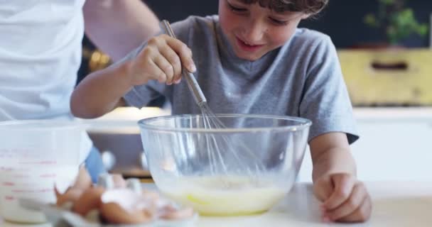 Where theres a whisk theres a way. 4k video footage of an adorable little boy baking with his father at home. — Video