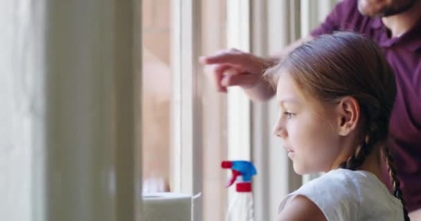 Like this, Dad. 4k video footage of a little girl cleaning windows with her father at home. – Stock-video