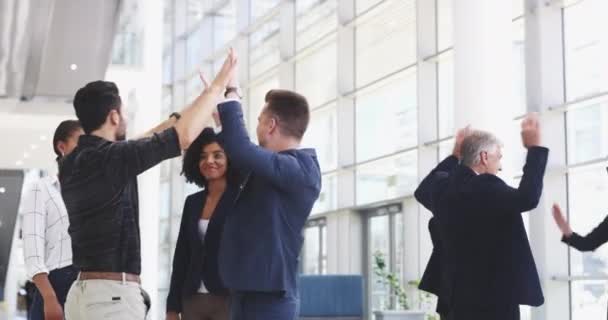 Raise the bar higher every time you win. 4k video footage of a group of businesspeople giving each other a high five in a modern office. — Video Stock