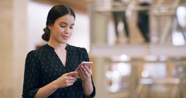 Zakelijke connecties maken. 4k videobeelden van een aantrekkelijke jonge zakenvrouw het verzenden van een sms-bericht tijdens het werk. — Stockvideo
