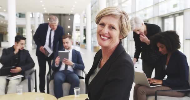 Shes sure of her abilities to succeed. 4k video footage of a businesswoman smiling in an office with her colleagues in the background. — Stock video