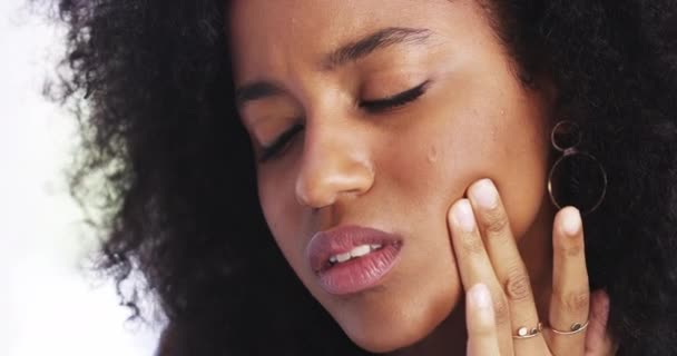 She needs to see a dentist. 4k video footage of a young businesswoman rubbing her jaw in discomfort while in her corporate office. — Stock video