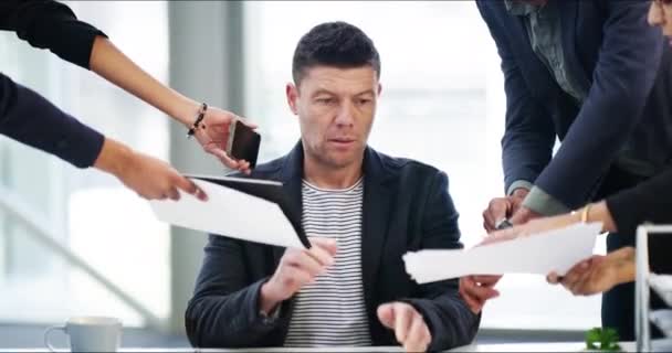Hes being dragged in all directions. 4k video footage of a businessman looking stressed while being overwhelmed with request from his colleagues in the workplace. — Video Stock