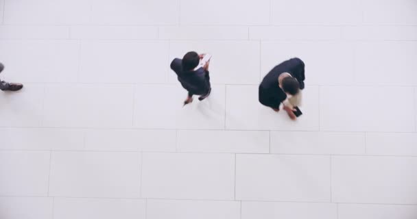 Moving around like busy ants. High angle 4k video footage of numerous businesspeople walking around on a busy day at work during the day. — Stockvideo