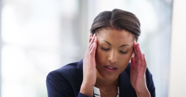 Trying to overcome her stress. 4k video footage of an attractive young businesswoman looking stressed while working on a desktop in her office. — Wideo stockowe