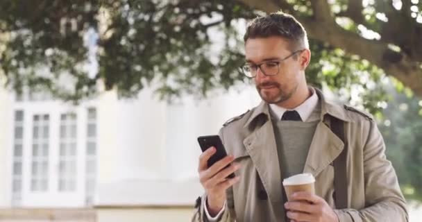 Checking his agenda for the day. 4k video footage of a businessman using a cellphone outside. — Video