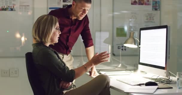 Faire avancer les affaires ensemble. Vidéo 4k de deux collègues travaillant tard sur un ordinateur dans un bureau. — Video