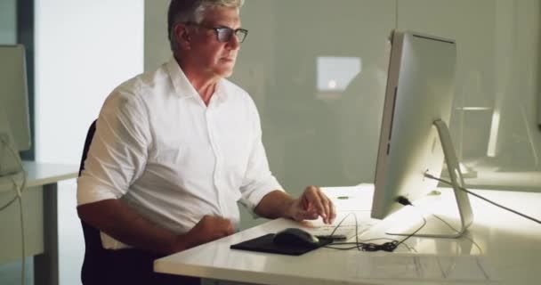 Vous ne pouvez pas atteindre la grandeur sans investir le temps et l'effort. Vidéo 4k d'un homme d'affaires mature travaillant tard sur un ordinateur dans un bureau. — Video