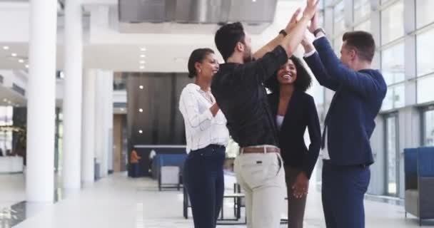 Un equipo empoderado es un equipo ganador. Imágenes de video de 4k de un grupo de empresarios que se dan unos cinco en una oficina moderna. — Vídeos de Stock