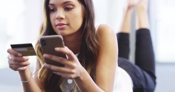 Time to pay the bills again. 4k video footage of an attractive young businesswoman doing online banking on her cellphone while relaxing in her corporate office. — Αρχείο Βίντεο