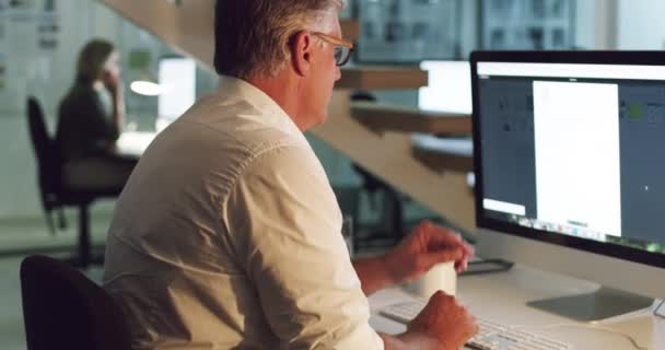 Succes ligt niet in het dromen, maar in het doen. 4k video van een volwassen zakenman werken laat op een computer in een kantoor. — Stockvideo