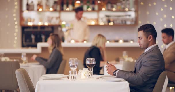 Parece que no viene. Imágenes de video de 4k de un hombre esperando su cita en un restaurante. — Vídeos de Stock