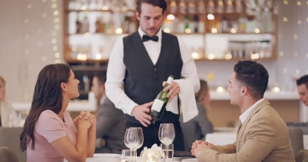 Is this wine what you chose to start the evening with. 4k video footage of a waiter serving a couple wine in a restaurant. — Wideo stockowe