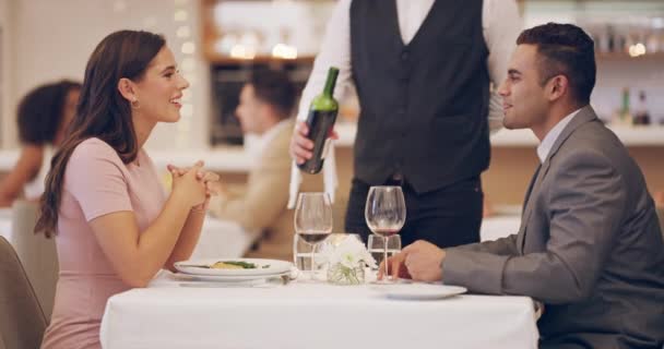 Wybrali czerwone wino do posiłku. Nagranie wideo 4k kelnera uzupełniającego kieliszki do wina dla par w restauracji. — Wideo stockowe