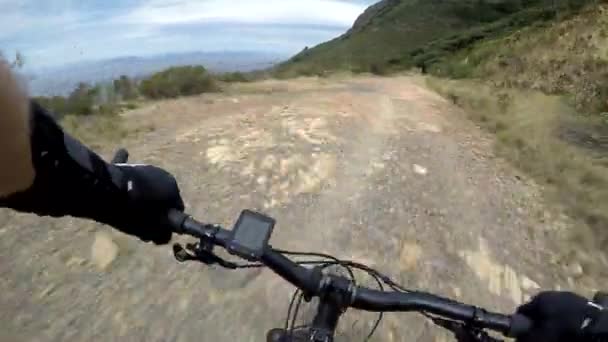 Navigating some tricky terrain. 4k POV video footage of an man cycling along a dirt trail on a mountain. — стоковое видео