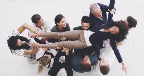Se lo merita. 4k filmato di un gruppo di uomini d'affari che lanciano la loro collega in aria per celebrare il suo successo. — Video Stock