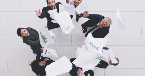 チームワークは成功のレシピです。空気中に彼らの書類を投げることによって祝うビジネスマンのグループの4k映像. — ストック動画