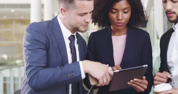 They help her to better her ideas. 4k video footage of three businesspeople discussing something on a digital tablet. — Wideo stockowe