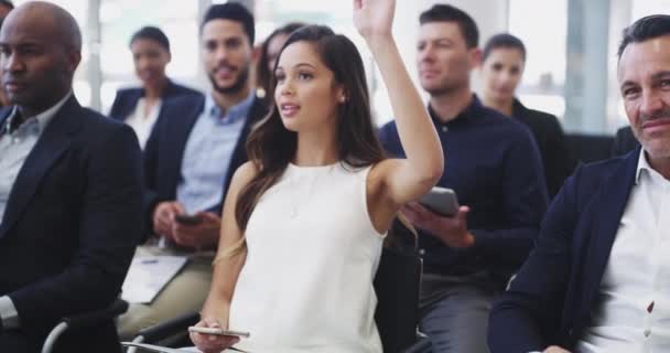 Ella está dispuesta a darle su opinión. 4k metraje de una joven empresaria levantando la mano para hablar durante una reunión de conferencia. — Vídeo de stock