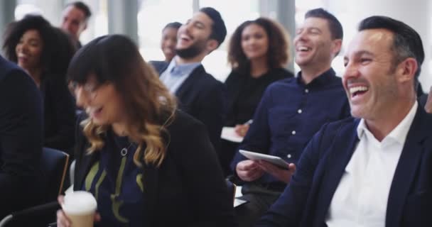 O orador está indo bem em manter o público entretido. Filmagem em vídeo 4k de um grupo de empresários rindo durante uma conferência. — Vídeo de Stock